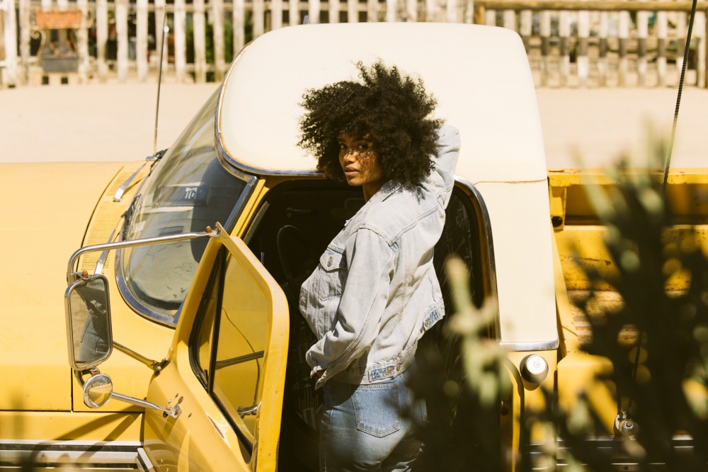 Lifestyle image by SternRep photographer Farhad Samari of a young black woman getting into a yellow truck