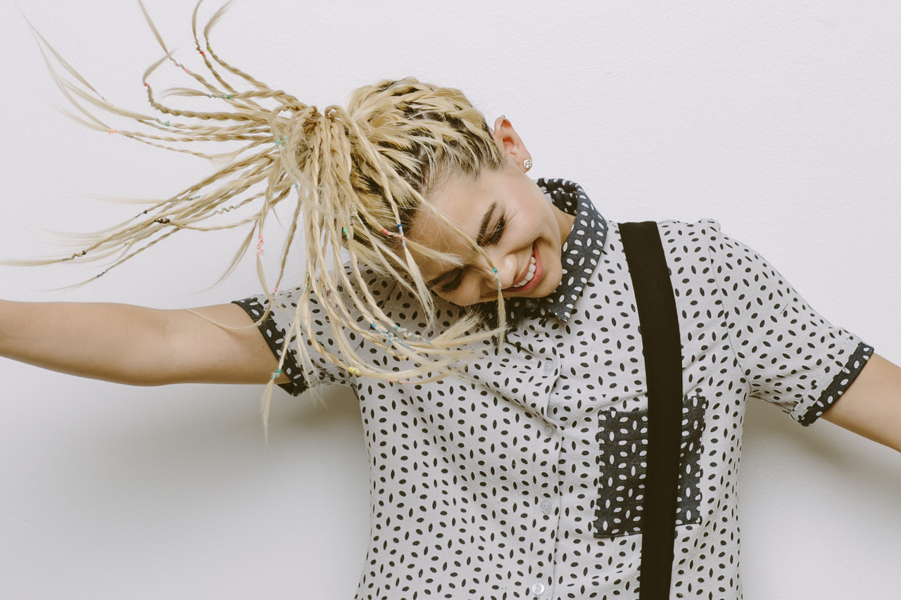 Lifestyle image by SternRep photographer Farhad Samari of a young women with blonde braids flinging her hair around